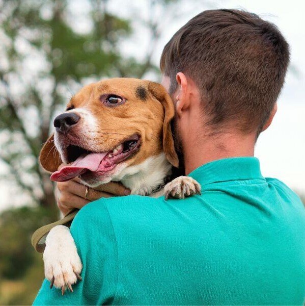 A man holding a beagle